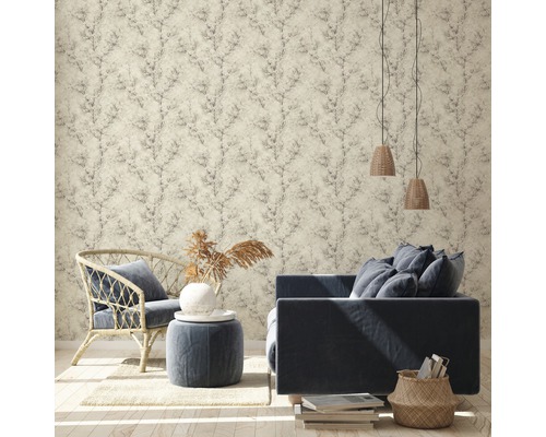 Woonkamer met patroonbehang, bank, stoel en decoratieve elementen voor een gezellige sfeer