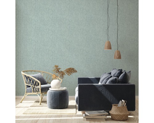 Licht, gestructureerd behang in een woonkamer met fauteuil, bank en decoraties.