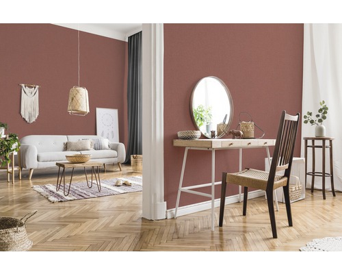 Woonkamer met patroonbehang, bank, tafel en decoraties voor een gezellige sfeer.