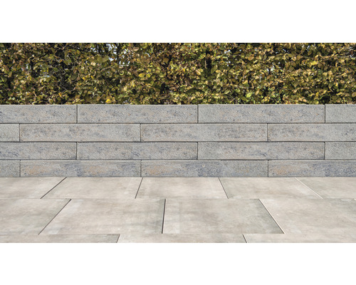 Betonnen stenen muur met bestrating in de tuin