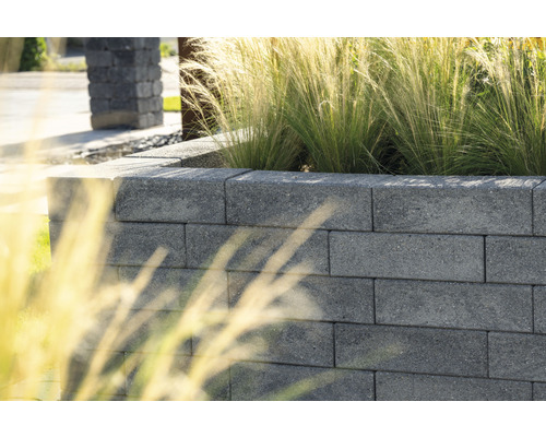 Tuinmuur gemaakt van betonstenen met beplanting