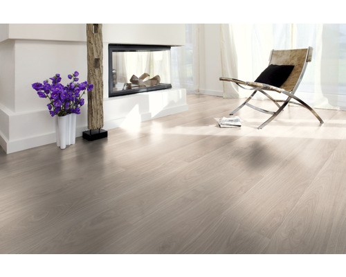 Lichte woonkamer met laminaatvloer, open haard en fauteuil