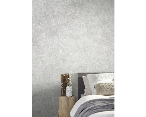 Lichte slaapkamer met bed, nachtkastje en decoratieve objecten tegen een grijze muur