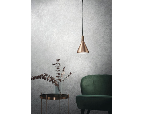 Modern interieur met hanglamp boven bijzettafel en fauteuil