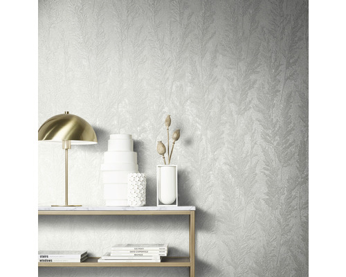 Wanddecoratie met gestructureerd behang met plantenmotief, tafel met decoratie en lamp