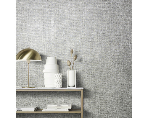 Close-up van een muur met textielbehang en een tafel met decoratie