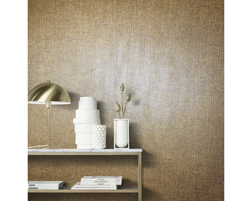 Close-up van een goudkleurig textielbehang met tafel, lamp en decoratie