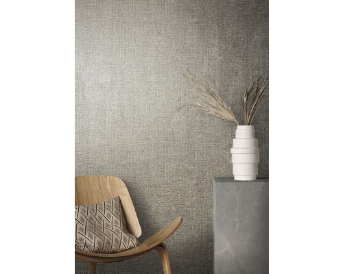 Close-up van een wand met textielbehang, een houten stoel en een decoratie in een vaas