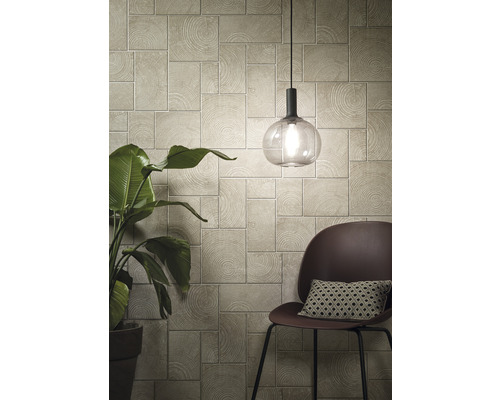 Woonkamer met wandpanelen in houtlook, lamp en stoel met kussen.