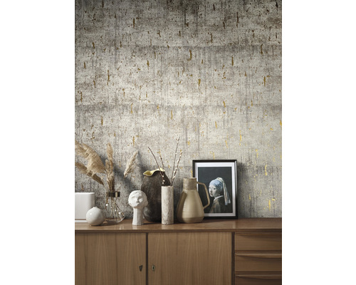 Close-up van een muur met grijs betonbehang en gouden accenten