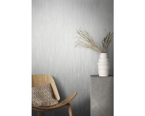 Scene met houten stoel, kussen, vaas met takken en behang