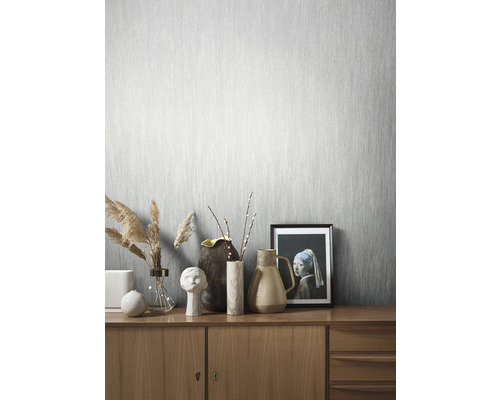 Lichte kamer met lichtgrijs behang en houten dressoir met decoraties