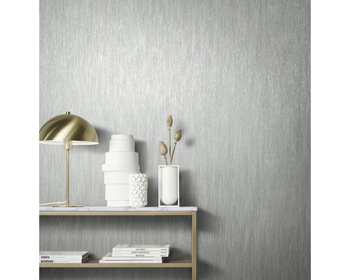 Close-up van een zilverkleurig behang met verticaal streepjespatroon in een heldere ruimte.