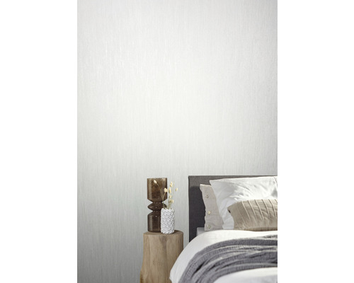 Woonkamer met bed en behang met structuur op de muur