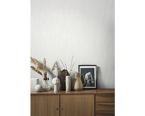 Licht, gestructureerd behang op een muur met dressoir en decoratie