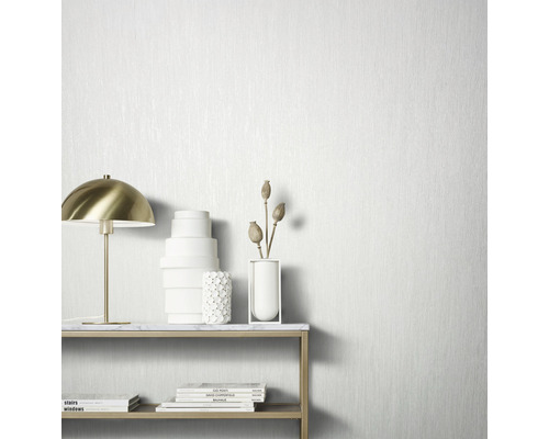 Decoratief stilleven met tafellamp, vazen en boeken tegen een gestructureerd behang