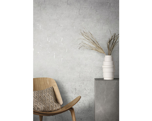 Decoratief interieur met houten stoel, kussen, vaas en droogbloemen op een sokkel.