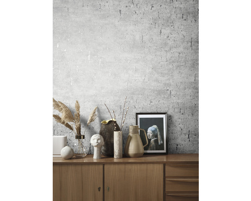 Woonkamer met patroonbehang en decoratieve elementen op een houten kast