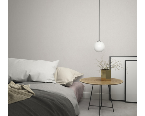 Lichte slaapkamer met bed, nachtkastje, bolvormige lamp, vaas en fotolijsten