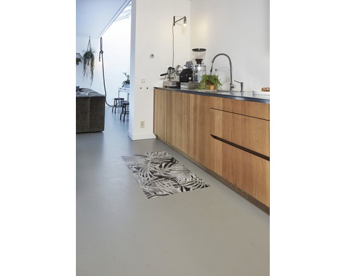 Moderne keuken met houten elementen, keukenmachine en een vloermat met motief