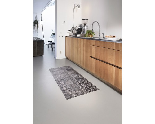 Interieurscène met keukenblok met houten fronten, keukenkraan, koffiemachine en een vloerkleed met motief op de vloer