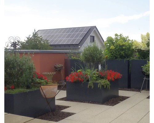 Terras met beplante bloembakken, tuinhuis en fotovoltaïsche installatie op het dak