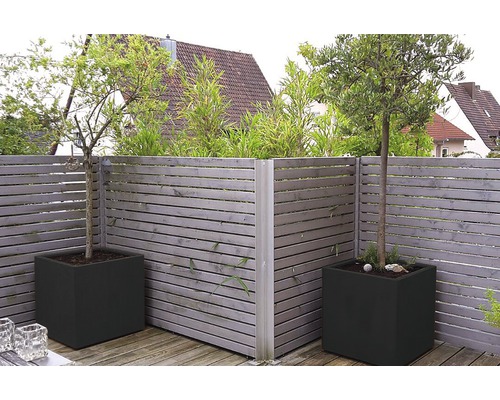 Tuinscene met houten schutting en vierkante plantenbakken met bomen