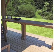 Houten terras met statafel, glazen en drankjes op de achtergrond