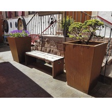 Buitenruimte met plantenbakken, bloemen en een bank