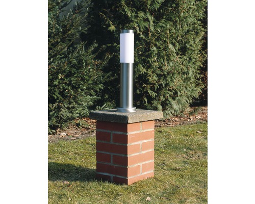 Tuinlamp van roestvrij staal op een bakstenen sokkel