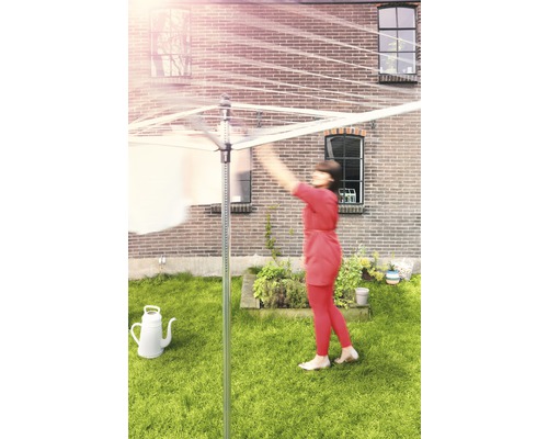 Draaimolen waslijn in de tuin met waslijnen en een persoon die kleding ophangt