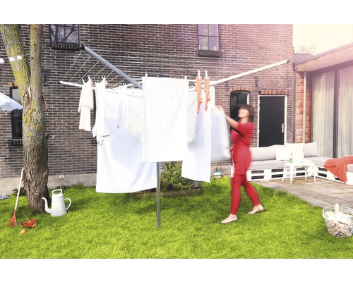 Droogmolen in de tuin met hangende was en vrouw