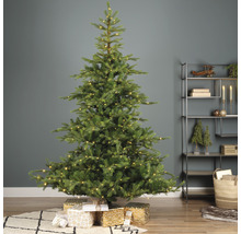 Versierde kerstboom met cadeaus in de woonkamer.