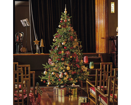 Feestelijk versierde kerstboom met geschenken in een ruimte met een podium