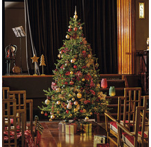 Feestelijk versierde kerstboom in een ruimte met een podium en stoelen