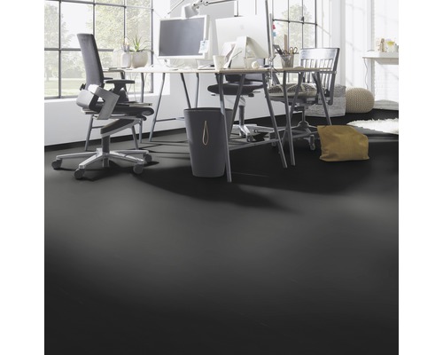 Kantoorruimte met bureaus, bureaustoelen en een zwarte vloer.