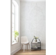 Lichte kamer met stoel, bijzettafel, plant en muursticker met bladdesign