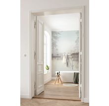 Badkamer met ligbad, houten vloer en muurschildering door open deur