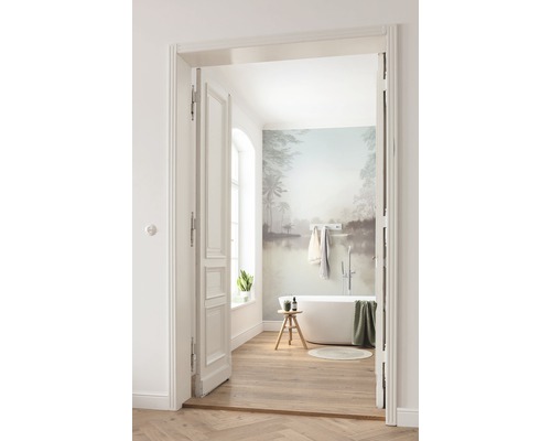 Badkamer met ligbad, houten vloer en muurschildering door open deur