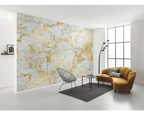 Woonkamer met grijs behang met gouden motief, stoel, bank en tafel