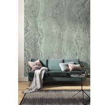 Woonkamer met bank, tapijt en behang met abstract patroon