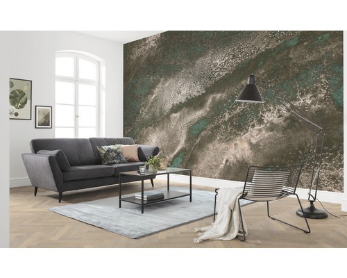 Woonkamer met grijze bank, tafel, lamp en fotobehang met abstract patroon
