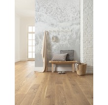Lichte kamer met houten vloer, bank, kussens en wanddecoratie