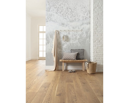 Lichte kamer met houten vloer, bank, kussens en wanddecoratie