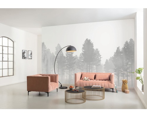 Woonkamer met bank, fauteuil, staande lamp en salontafels voor een fotobehang met bosmotief.