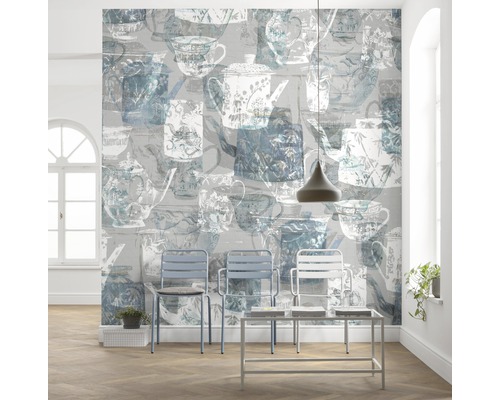 Lichte kamer met behang met theepotten en kopjes, plus stoelen en een tafel