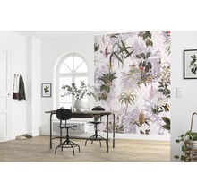Een lichte kamer met een tafel, stoelen en een muur met botanisch behang.