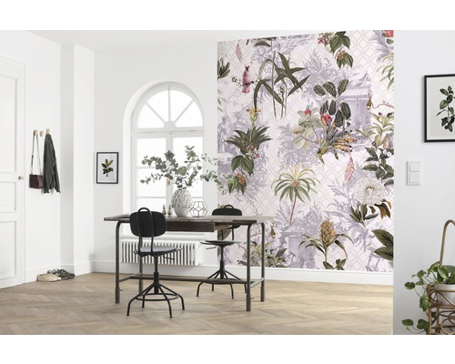 Een lichte kamer met een tafel, stoelen en een muur met botanisch behang.