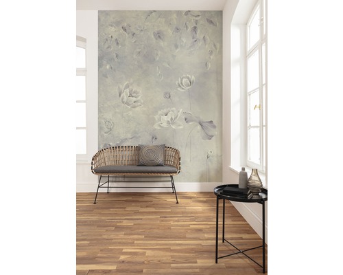 Woonkamer met bloemenbehang, bank en bijzettafel.