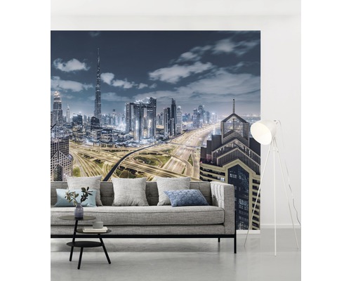 Woonkamer met fotobehang van een skyline in de nacht en een grijze bank